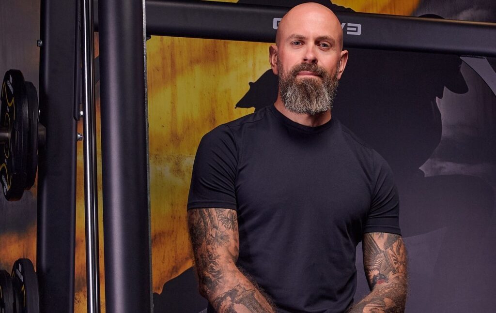 Personaaltreener Toomas Karting istumas jõusaalis treeningala ees